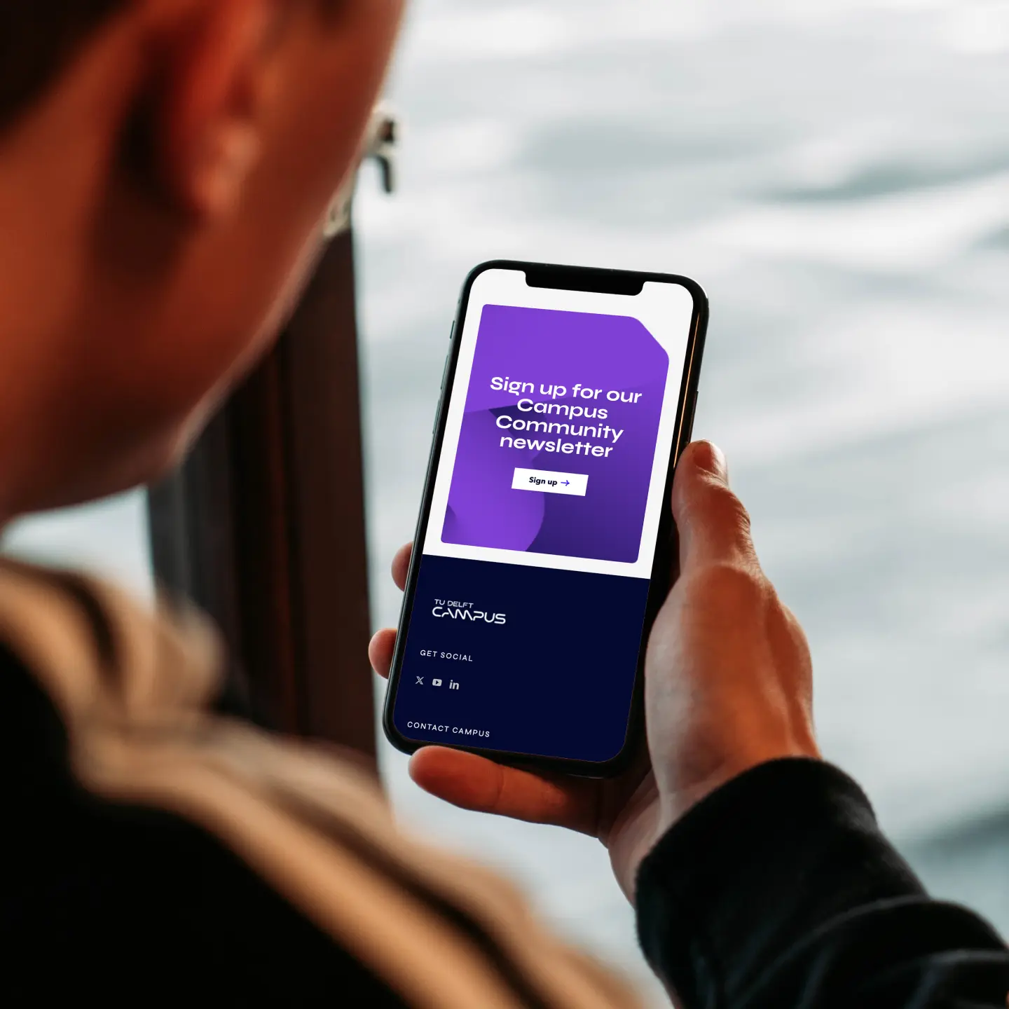 Telefoon met afbeelding van TU Delft nieuwsbrief